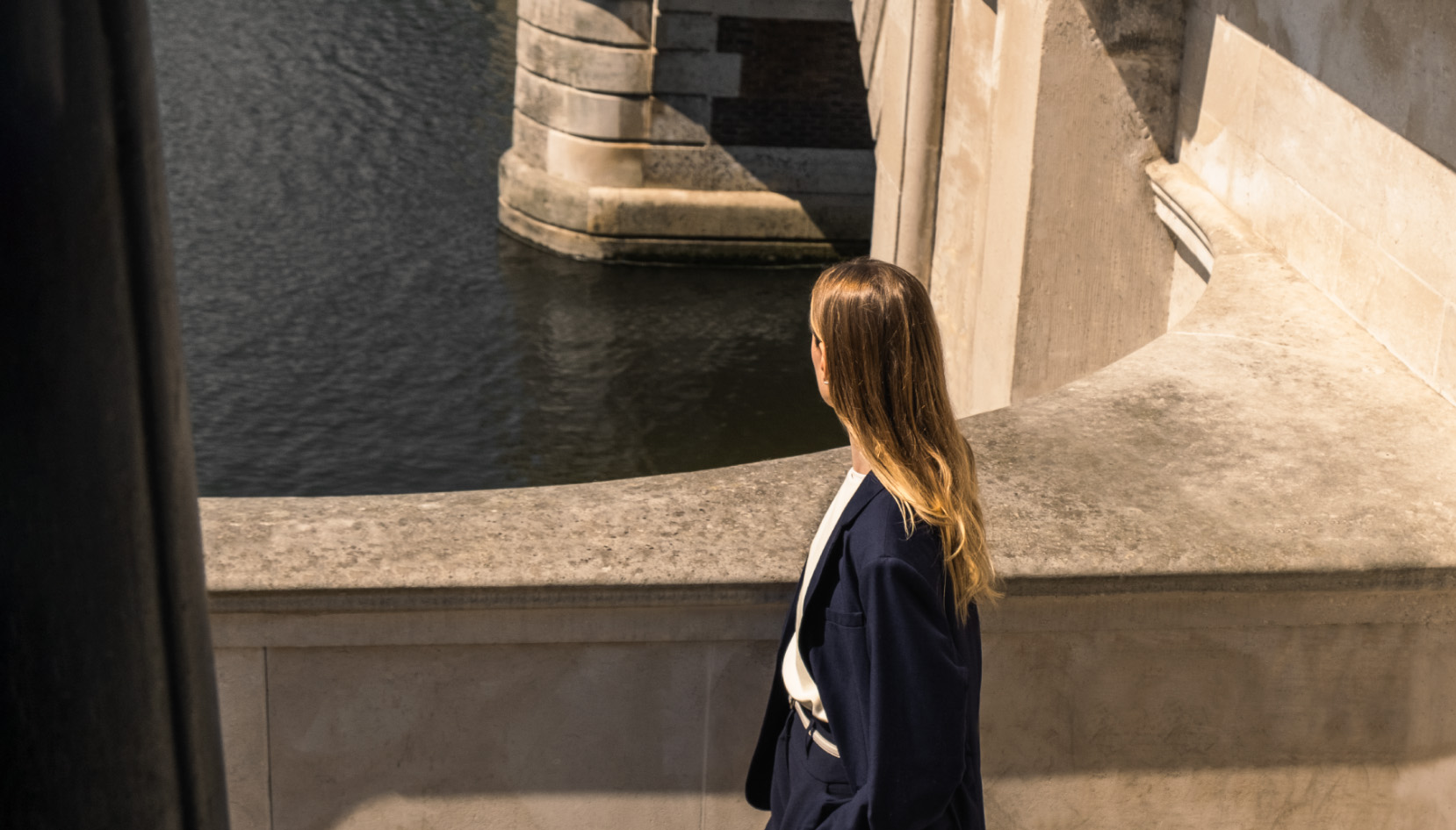 Woman walking by the river near bridge